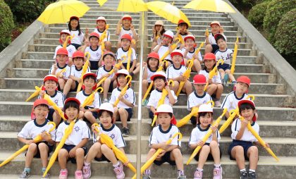 寄贈先である長崎県諫早市立上山小学校の1年生。黄色い学童傘が子どもたちの交通事故防止に役立つことを願っています